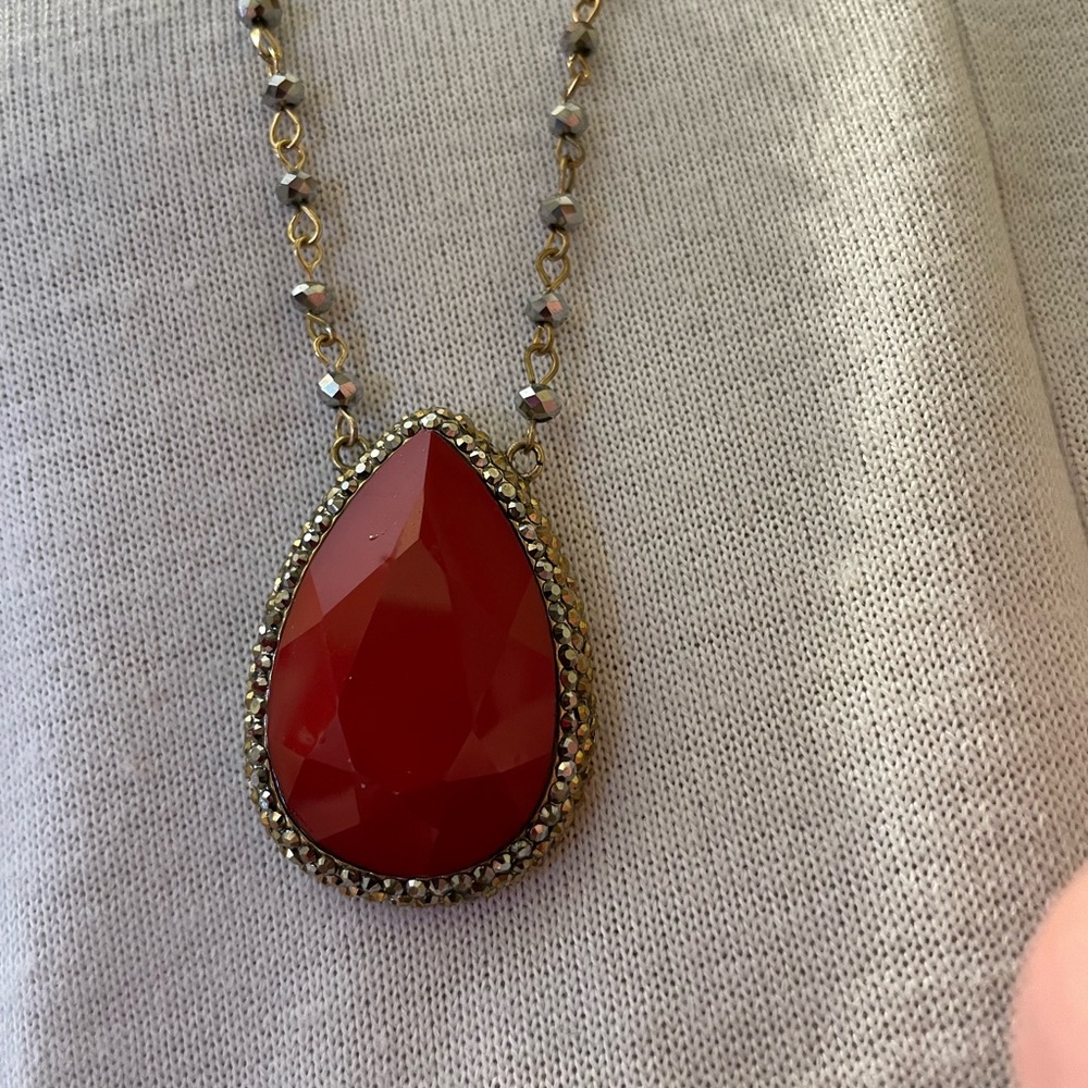 Long gold chain with red stone teardrop pendant and smoky Czech crystal accents.